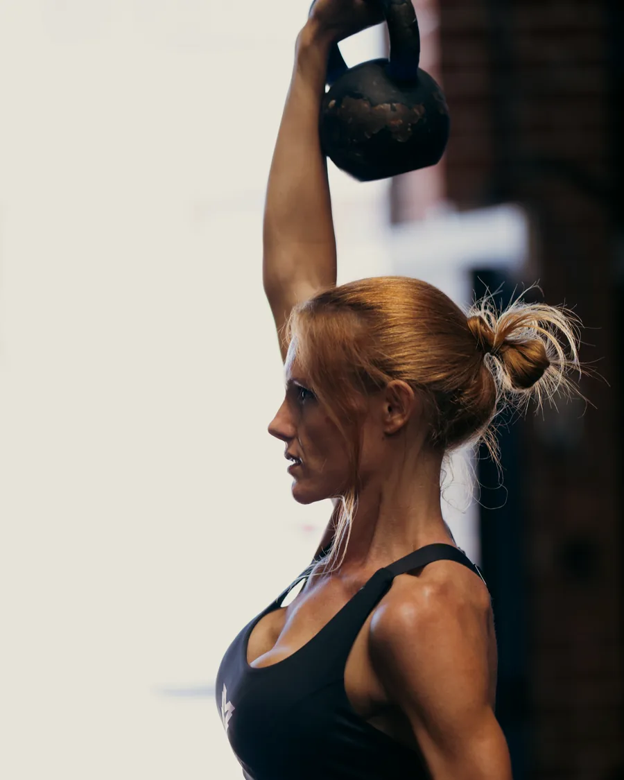 Athlete climbing a rope in a dark gym